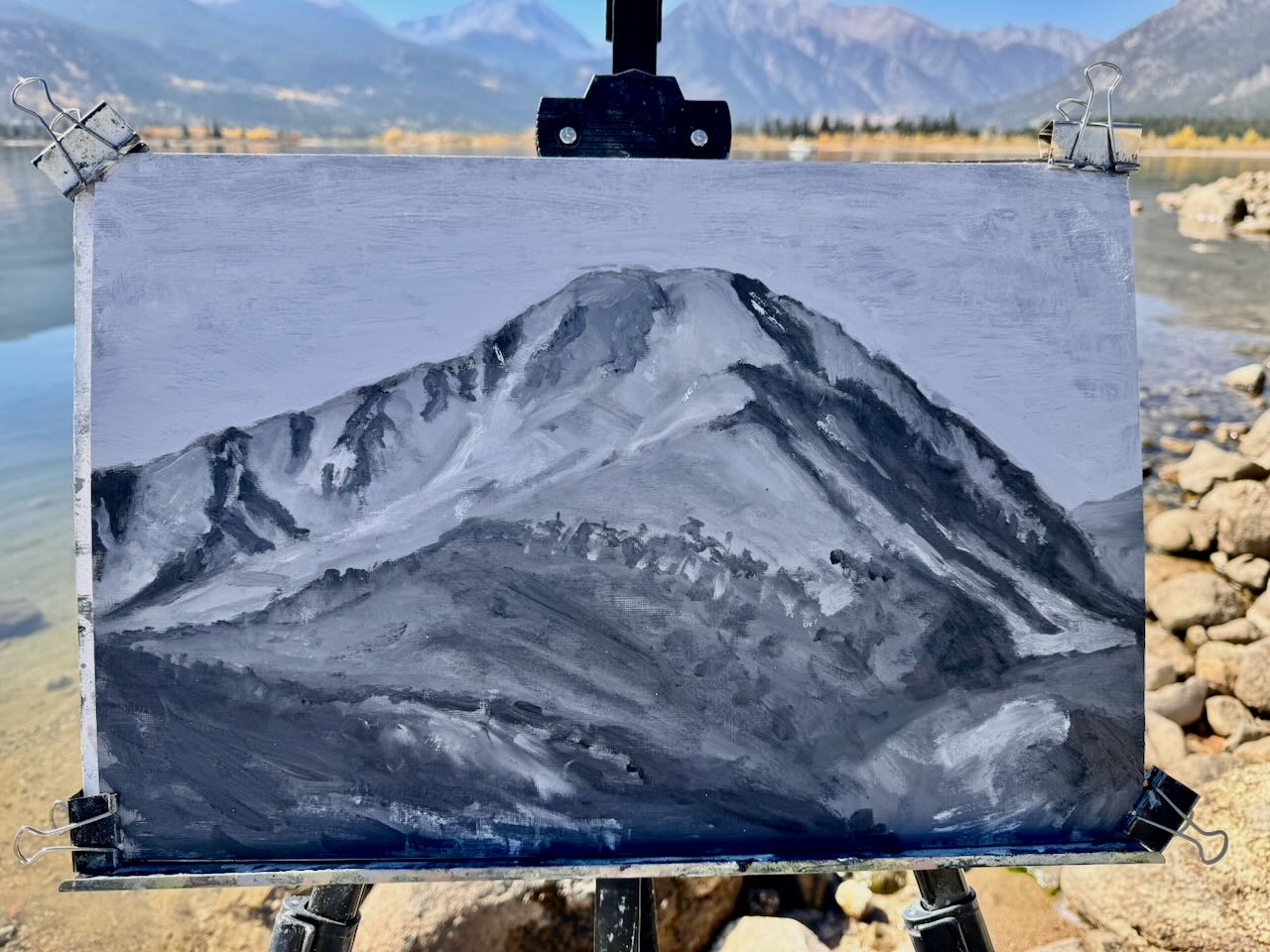 Plein air painting of Twin Lakes clipped to an easel in front of the actual shoreline.